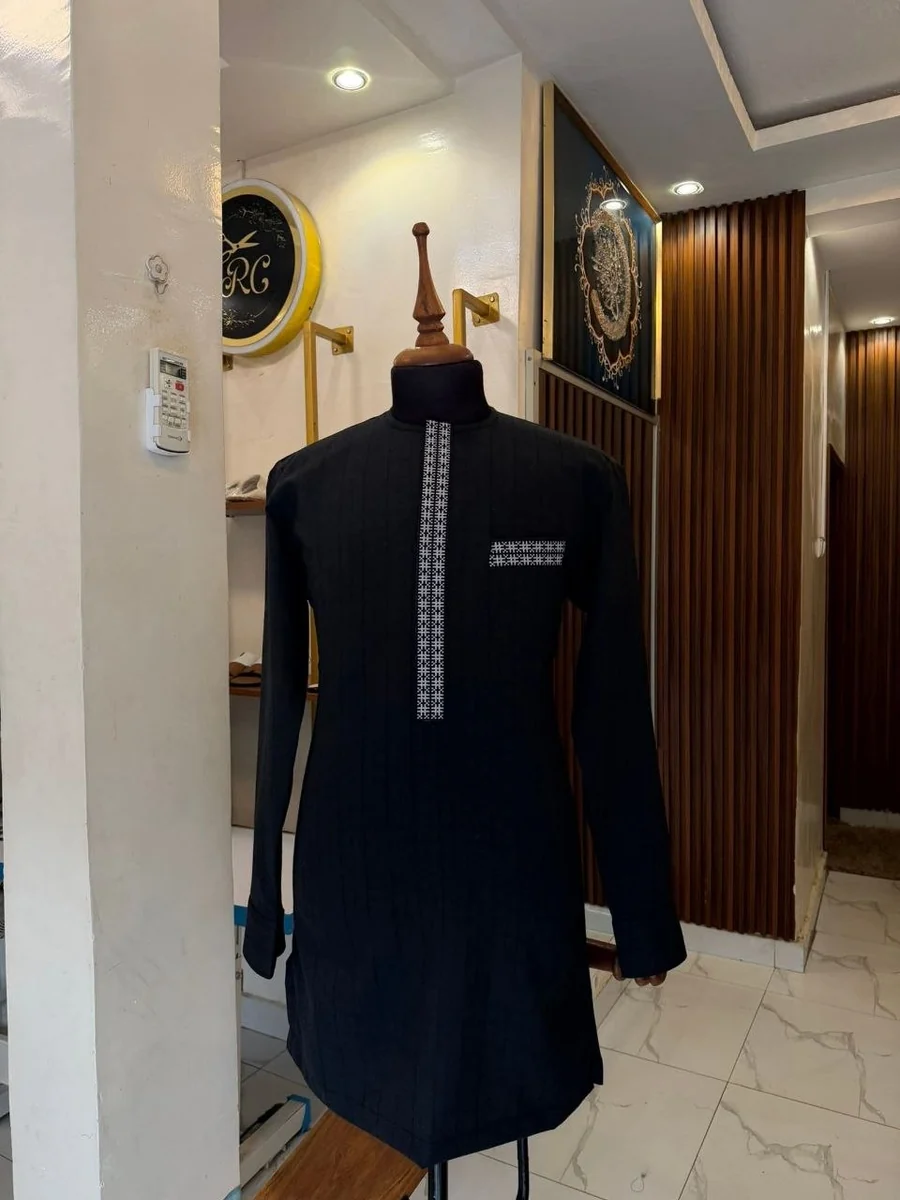 Tunique noire à patte brodée, sur buste, dans le salon Rima Couture